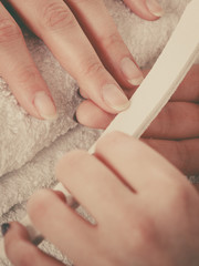Obraz na płótnie Canvas Woman getting manicure done file nails