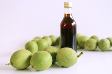 Excellent liqueur made with unripe green nuts and alcohol. Liquor in bottle on a wooden table....