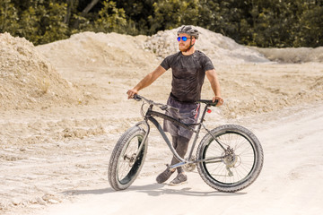 Fototapeta na wymiar Training a bicyclist in a chalky quarry. A brutal man on a fat bike. 