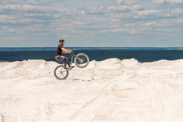Fototapeta premium Training a bicyclist in a chalky quarry. A brutal man on a fat bike. 