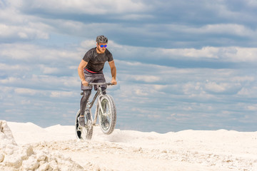 Fototapeta premium Training a bicyclist in a chalky quarry. A brutal man on a fat bike. 