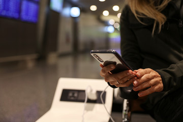 Stay connected during your travel and flight, Woman using public phone charging station at the...