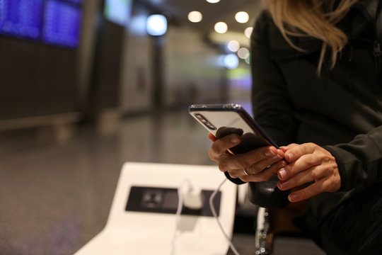 Stay Connected During Your Travel And Flight, Woman Using Public Phone Charging Station At The Airport