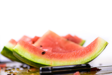 Some of the watermelon was already eaten. Several slices on the table with a white background