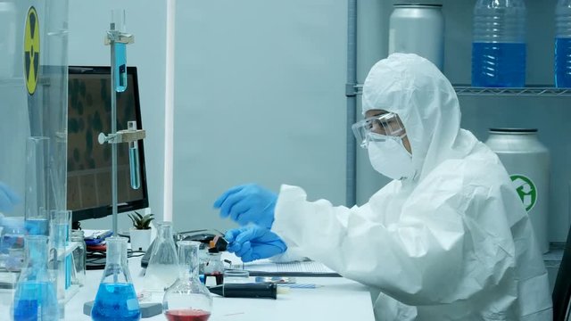 Scientists in a Coverall Conducting a Research at Laboratory. People with science concept. 4K Resolution