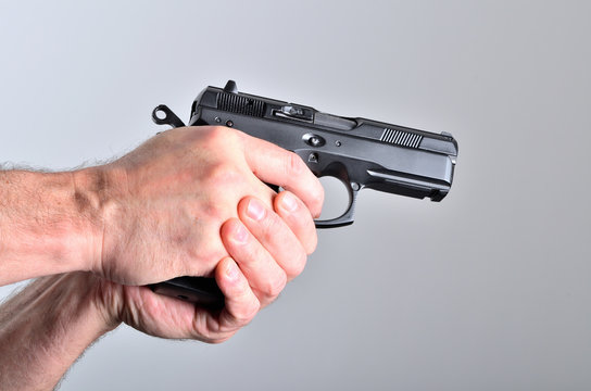Hand of man aiming with a pistol - side view