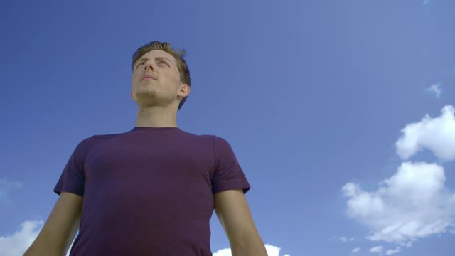 Close-up of freerunner looking into the distance on a metal railing. The parcour runner then jumps out of the frame. 