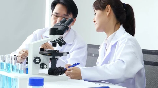 Male scientist advise to team how to work. Asian Scientist working together at laboratory. People with medical, science, doctor, healthcare concept. 4K Resolution.
