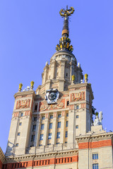 Fototapeta premium Building of Lomonosov Moscow State University (MSU) with national emblem of USSR and star on the spire against blue sky