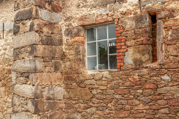 Fototapeta na wymiar Stone wall with black window 1
