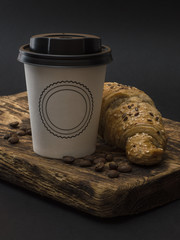 paper cup with coffee on a wooden board. 