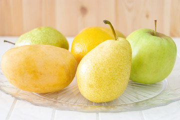 Still life Fruit, apple, pear, mango, lemon on glass plate. Concept Autumn harvest.