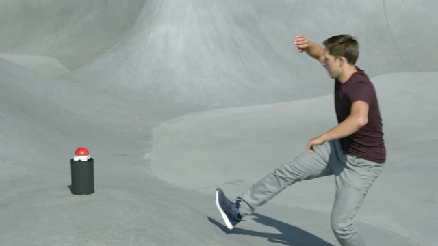 parkour runner enters the frame and runs to a red game show buzzer and presses it in a urban environment in slow-motion. 