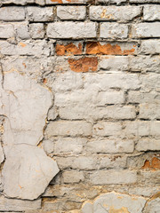 Texture of an old brick wall with peeling plaster