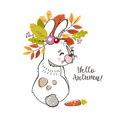 a cute rabbit  hare with a wreath of autumn leaves and berries on his head with the inscription hello autumn and the carrot