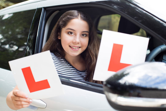 Portrait Of Teenage Girl Passing Driving Exam Holding Learner Plates