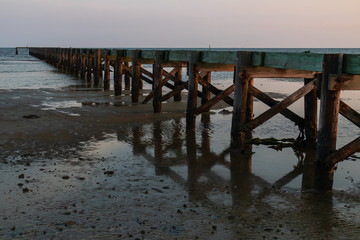 Fototapeta premium Old wooden pier and ocean in background at sunset
