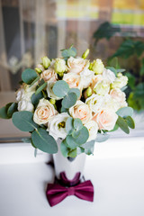 Wedding bouquet of white and pink roses with a burgundy butterfly