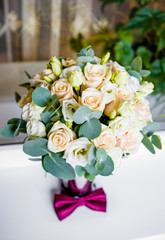 Wedding bouquet of white and pink roses with a burgundy butterfly