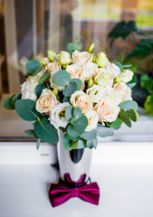 Wedding bouquet of white and pink roses with a burgundy butterfly