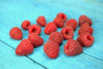 Healthy food,agriculture,harvest and fruit concept: close-up fresh raspberries on a wooden blue background.