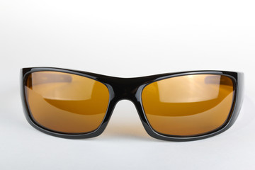 Sunglasses with black plastic frame and yellow glass on a white background