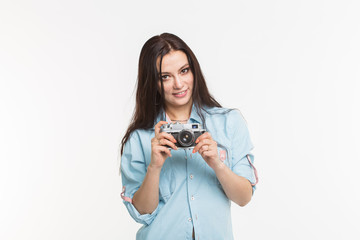 Photographer, hobby and people concept - Young brunette woman with retro camera on white background