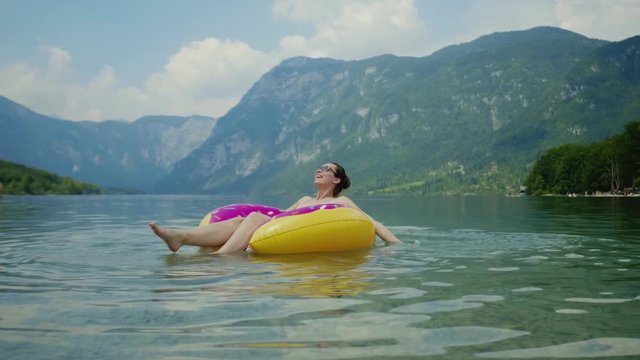 Beautiful woman swimming on inflatable ring in water