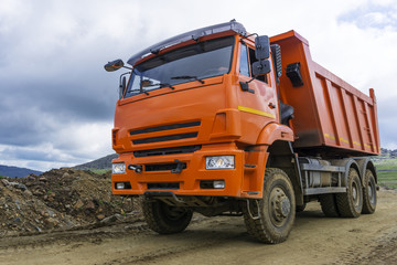 dump truck rides on the mountain road under construction