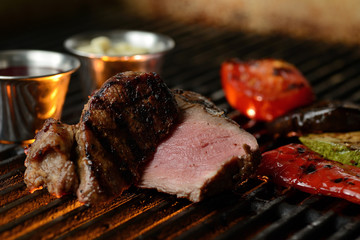 Grilled meat with vegetables and sauce, on the grill