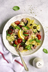 Pasta salad with tuna and vegetables ( cherry tomato, cucumber, green bean and black olives ) . Top view.