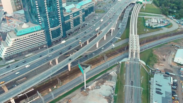flight of the camera over the traffic junction. Aerial top view of road junction in Moscow from above, automobile and train traffic and jam of many cars, transportation concept.