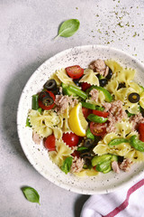 Pasta salad with tuna and vegetables ( cherry tomato, cucumber, green bean and black olives ) . Top view.