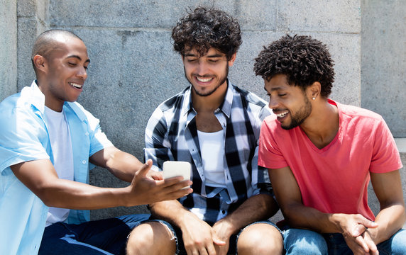 Group of african american and caucasian hipster manstreaming movie on phone