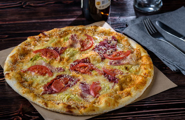Pizza with a bottle of beer on a wooden table