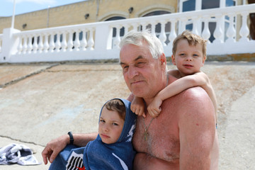 Fototapeta na wymiar Grandfather with grandsons on beach