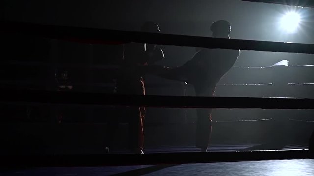 Guys preparing for a kickboxing competition. Silhouette. Slow motion