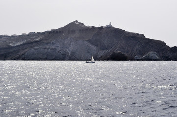 The yacht sails in front of the Akrotiri Lighthouse.