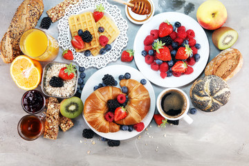 breakfast on table with waffles, croissants, coffe and juice.