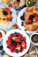 breakfast on table with waffles, croissants, coffe and juice.