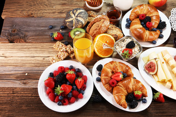 breakfast on table with waffles, croissants, coffe and juice.