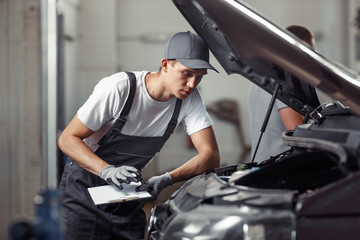 Fototapeta na wymiar A mechanic is fixing a car at a car service
