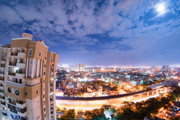 Night aerial cityscape of a modern indian city with skyscrapers, residences, buildings, a busy...