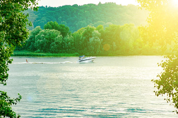 Woman on a water ski after a boat on a nature background