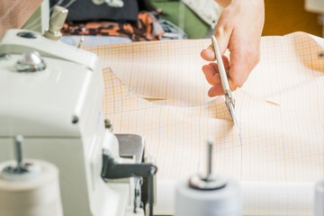 worker of sewing production uses scissors for cutting of fabric. Sewing production line