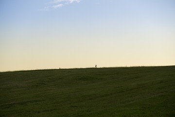 Fototapeta na wymiar People walking on a meadow during sunset. Slovakia