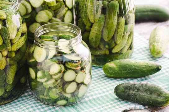Fresh pickles in and around a jar
