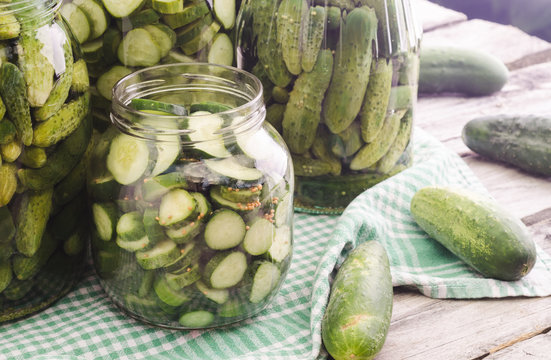 Fresh pickles in and around a jar