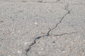Crack on gray asphalt, close-up, creative background