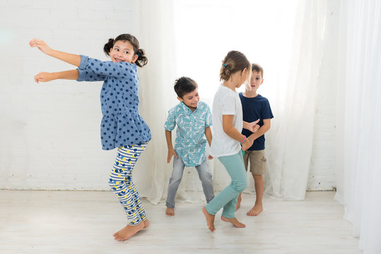 Four Children Dancing To A Radio Indoors